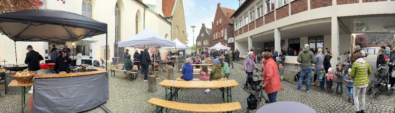 Eine Veranstaltung in einer Fußgängerzone mit zahlreichen Bierbänken, Menschen, Schirmen und einem Essensstand, umgeben von traditionellen Gebäuden. Eine Veranstaltung in einer Fußgängerzone mit zahlreichen Bierbänken, Menschen, Schirmen und einem Essensstand, umgeben von traditionellen Gebäuden.