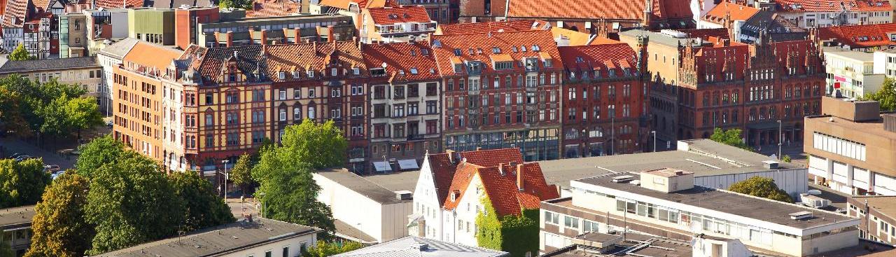 Das Luftbild zeigt die Dächer der Altstadt Hannovers mit ihrer Fachwerkfassade bei sonnigem Wetter mit Blick auf den Turm der Marktkirche. 