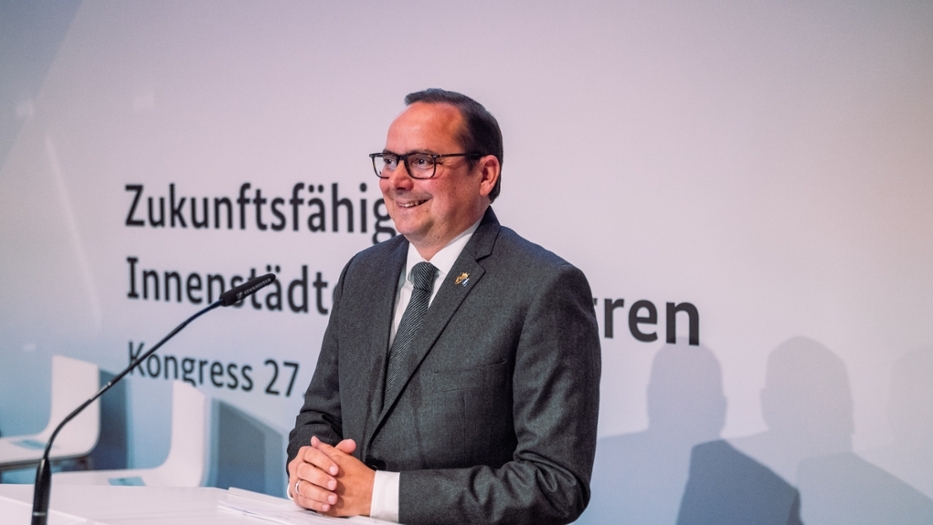Der Oberbürgermeister der Stadt Essen gibt eine thematische Einführung. Er steht lächelnd hinter einem Podium. Der Oberbürgermeister der Stadt Essen gibt eine thematische Einführung. Er steht lächelnd hinter einem Podium.