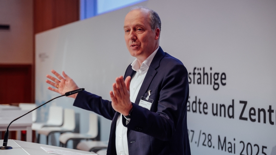 Der Abteilungsleiter vom Bundesinstitut für Bau-, Stadt- und Raumforschung trägt angeregt einen Vortrag vor. Der Abteilungsleiter vom Bundesinstitut für Bau-, Stadt- und Raumforschung trägt angeregt einen Vortrag vor.
